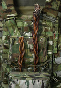 Braided bully pizzle dog chews displayed in medium and jumbo sizes on a camouflage tactical vest.