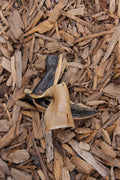 Camel skin dog chew pieces displayed on a bed of natural wood chip